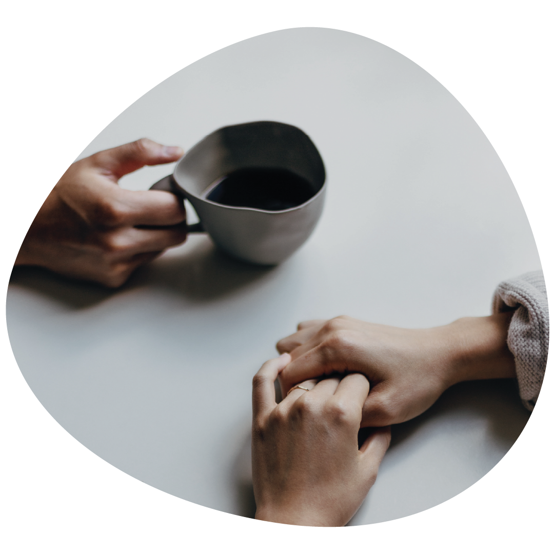 Two sets of hands across from a table together.